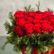 A Merry Little Christmas centerpiece with red roses, greenery, and gold ornaments, available for same-day delivery by Beverly Hills Florist.