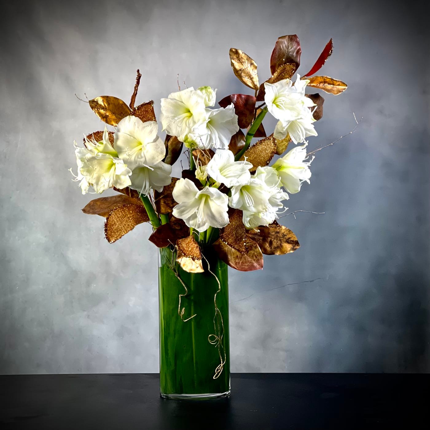a-modern-christmas-amaryllis-holiday-centerpiece-bh-florist.j A Modern Christmas arrangement featuring amaryllises in a sleek 36-inch vase, perfect for holiday decor, available for same-day delivery by Beverly Hills Florist.