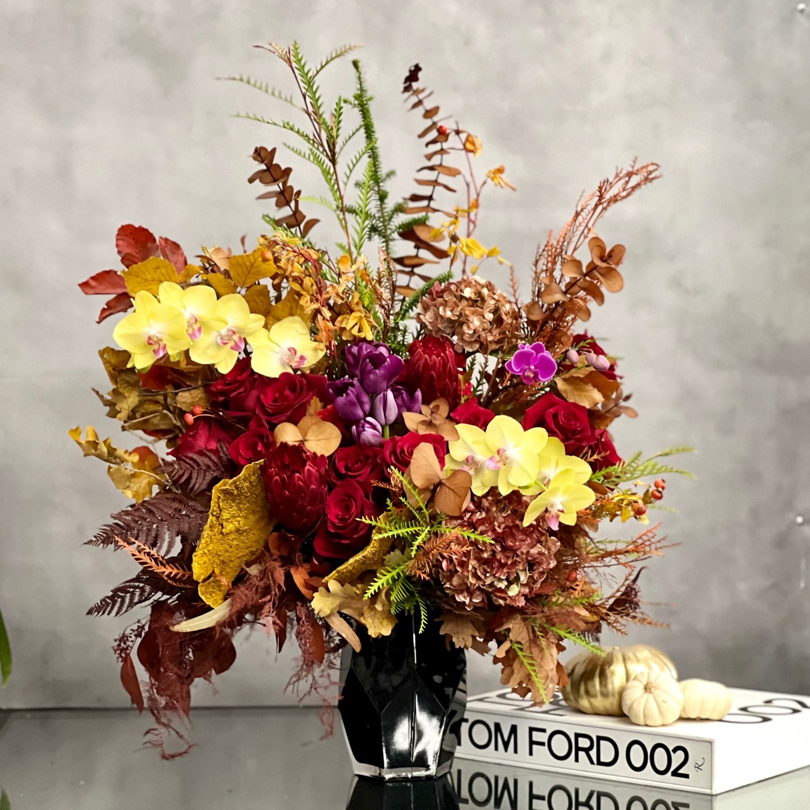 autumn-harmony-fall-flowers-orchids-black-geometric-vase-beverly-hills-florist.2 Autumn Harmony arrangement with fall flowers in vibrant reds, oranges, yellows, and browns, set in a black geometric vase, available for same-day delivery by Beverly Hills Florist.
