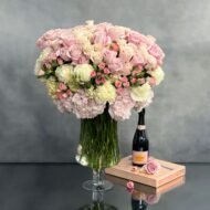 Elegant arrangement of over 100 pale pink roses and peonies in a sleek glass vase, 28 inches tall, designed by Beverly Hills Florist.