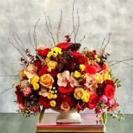 Brighten their day with this vibrant bouquet. This bouquet dashingly displays peach roses and garden roses, peach and pink orchids, yellow, red and spray roses, and pink dutch double tulips. A gorgeous mix of bold, rich and bright flowers is the best way to boost any mood and for any occasions! Overall 17x 12.