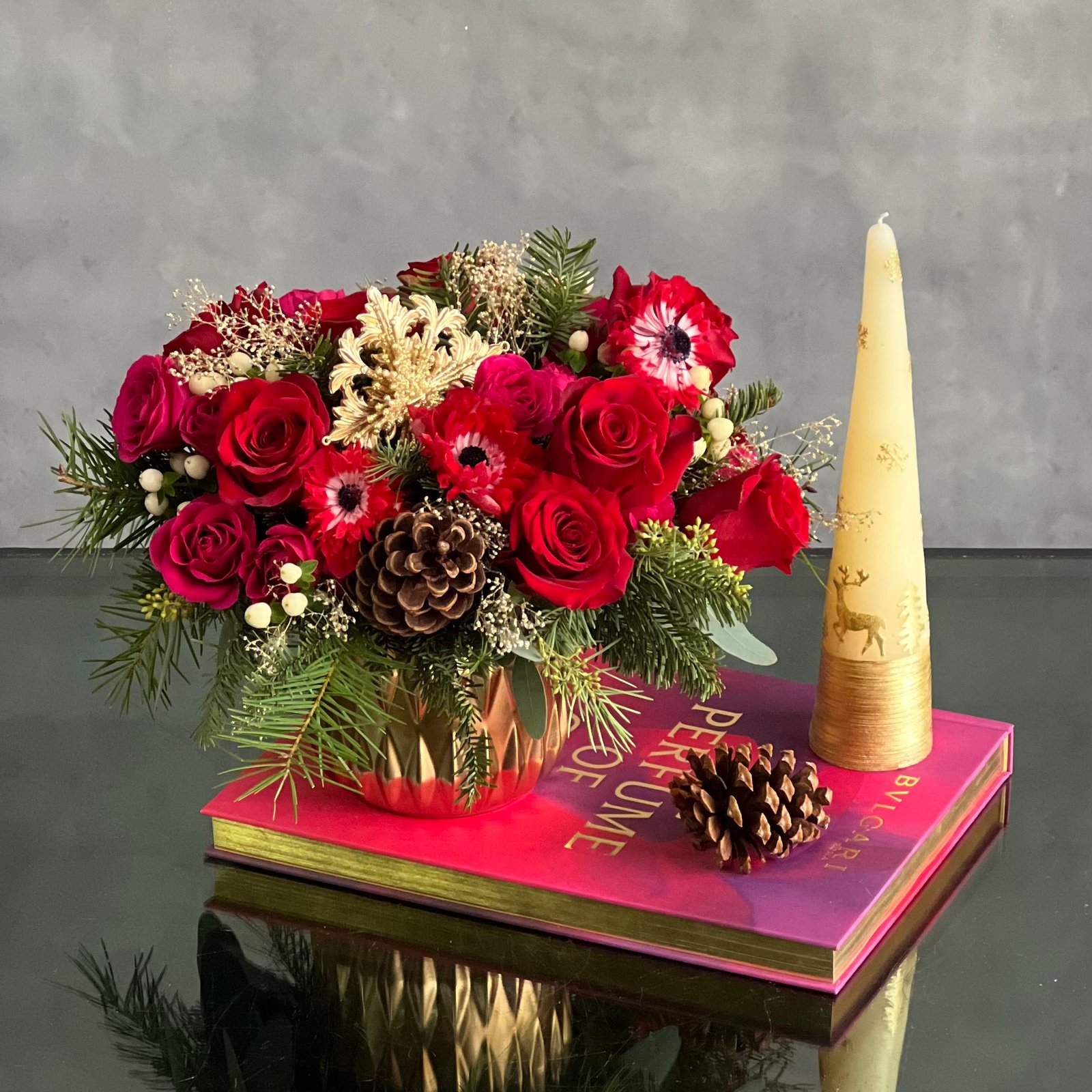 yuletide-spirit-holiday-floral-arrangement-red-roses-gold-vase Yuletide Spirit holiday floral arrangement with red roses, spray roses, natural accents, and a gold ornament in a brushed gold cylinder vase.